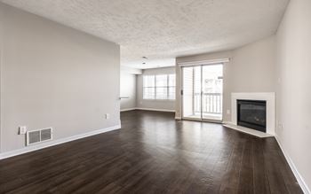 A spacious living room with wood flooring and a fireplace